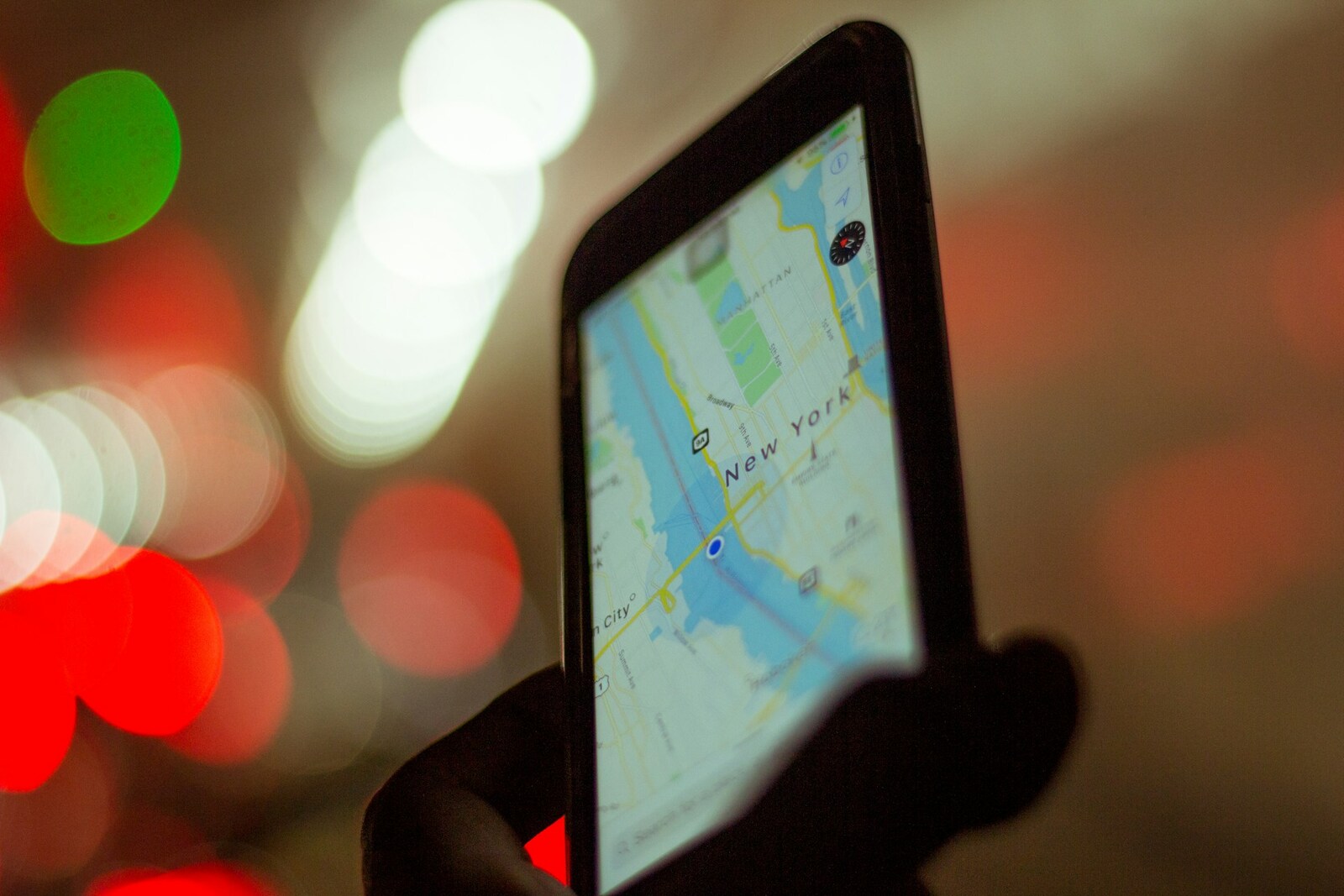 صورة توضيحية: شخص يمسك هاتفًا يعرض خريطة GPS (Enrique Alarcon / Unsplash)